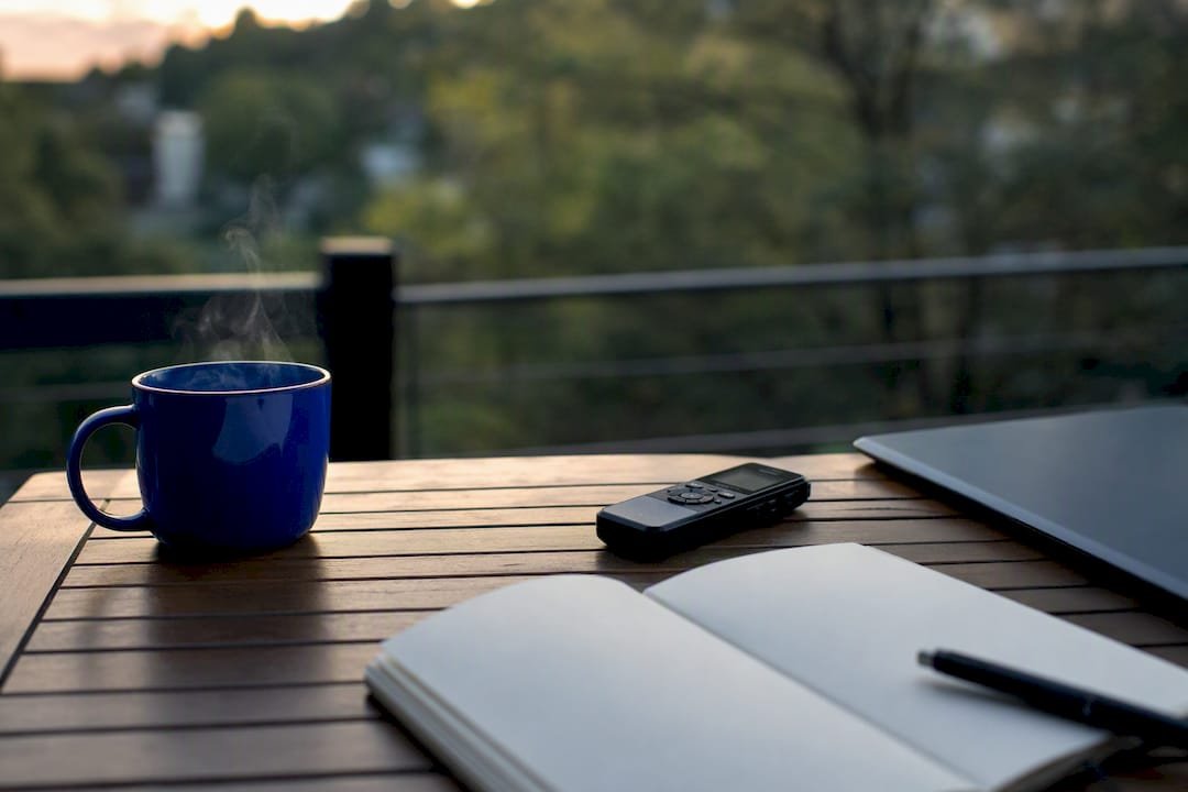 Coffee cup next to work tools on desk